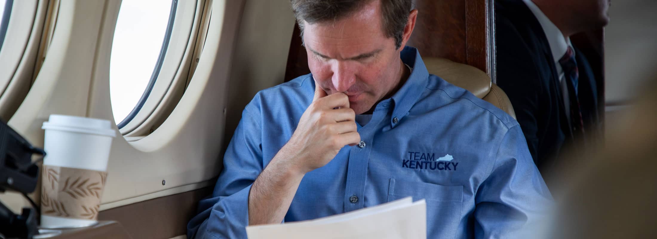Governor Andy Beshear during a press conference at podium while wearing a mask