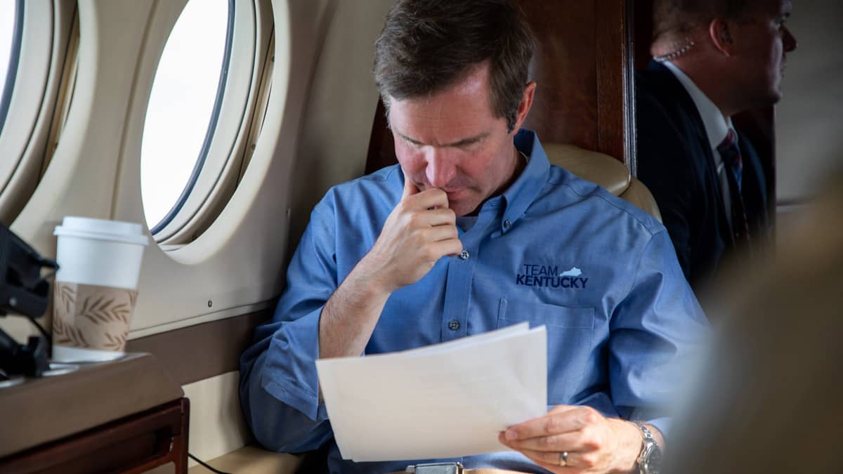 Governor Andy Beshear during a press conference at podium while wearing a mask